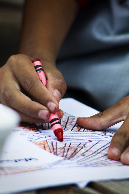 mano pequeña coloreando con cera